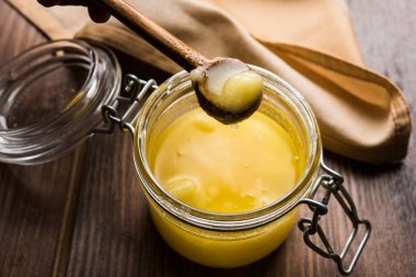 Desi Ghee veya cam veya bakır kapsayıcı veya kaşık, seçici odak ile seramik kavanoz içinde eritilmiş tereyağı