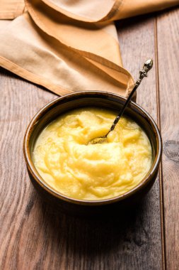 Desi Ghee veya cam veya bakır kapsayıcı veya kaşık, seçici odak ile seramik kavanoz içinde eritilmiş tereyağı