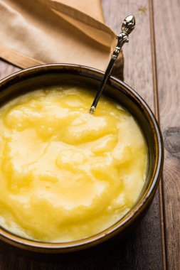 Desi Ghee veya cam veya bakır kapsayıcı veya kaşık, seçici odak ile seramik kavanoz içinde eritilmiş tereyağı