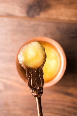 Desi Ghee veya cam veya bakır kapsayıcı veya kaşık, seçici odak ile seramik kavanoz içinde eritilmiş tereyağı