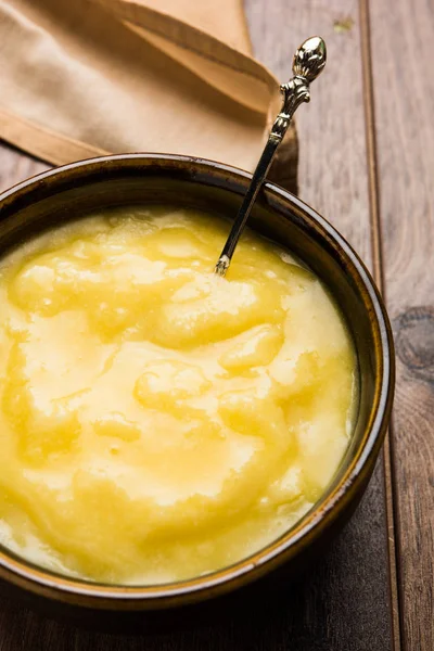Desi Ghee veya cam veya bakır kapsayıcı veya kaşık, seçici odak ile seramik kavanoz içinde eritilmiş tereyağı