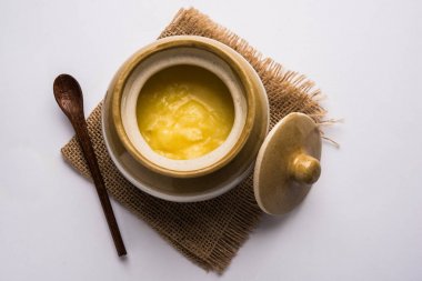 Desi Ghee veya cam veya bakır kapsayıcı veya kaşık, seçici odak ile seramik kavanoz içinde eritilmiş tereyağı