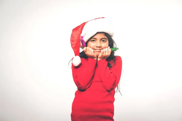 Cute Little Indian Girl Wearing Santa Hat Celebrating Christmas While — Stock Photo, Image