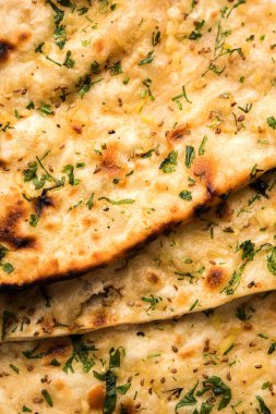 Sarımsak ve kişniş naan, bir tabak içinde sunulan bir türdür Hint ekmek veya sarımsak aromalı roti