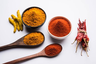 zerdeçal ve kırmızı biber tozu beyaz ya da siyah arka plan üzerinde seramik bir kasede yığını 