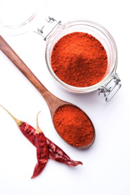 Kırmızı renkli arka plan veya düz arka plan üzerinde kırmızı biber tozu yığını üzerinde kurutulmuş kırmızı biber ile bir kasede Chilly Powder