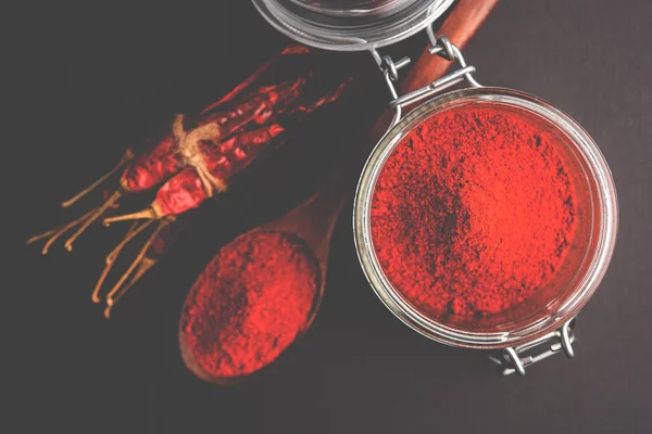 Red Chilly Powder in a bowl with dried red chillies over colourful background or pile of red chilli powder over plain background