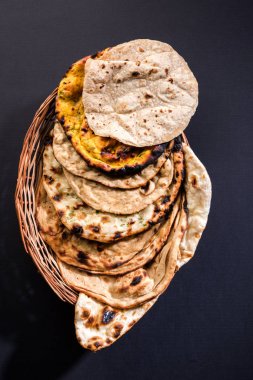 Assorted Indian Bread Basket includes chapati, tandoori roti or naan, paratha, kulcha, fulka, missi roti clipart