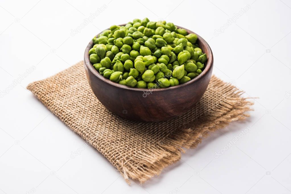 Fresh Green Chickpeas or Chick peas also known as harbara or harbhara in hindi and Cicer is scientific name, served in a wooden bowl or plate. selective focus
