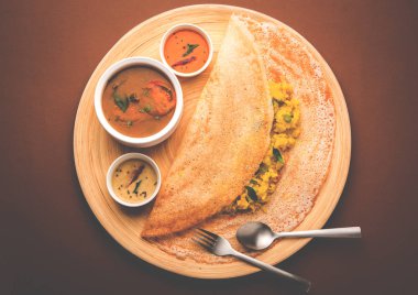 Masala dosa with chutney and sambar and potato sabzi. Cone, triangle or roll shape, selective focus clipart