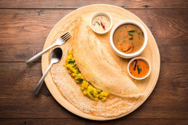 Masala dosa Hint turşusu ve sambar ve patates sabzi ile. Koni, üçgen veya rulo şekli, seçici odak