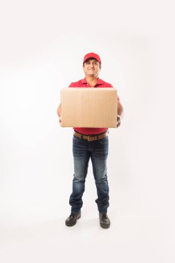 Teslimat kavramı - kırmızı ya da yeşil üniformalı yürüyüş veya atlama veya denetimi veya karton kutu ile kopya alanı sunan mutlu Hint veya teslim erkeklere portresi