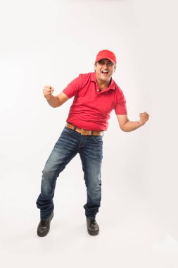 Teslimat kavramı - kırmızı ya da yeşil üniformalı yürüyüş veya atlama veya denetimi veya karton kutu ile kopya alanı sunan mutlu Hint veya teslim erkeklere portresi