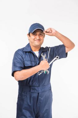 Indian happy auto mechanic in blue suit and cap holding spanner tool in action, isolated over white background clipart