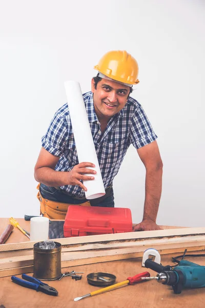 Handsome Indian Carpenter or wood worker in action, isolated over white background