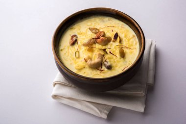 bir Hint tatlı kuru meyve Topingler ile kahverengi pişmiş toprak kapta kheer ya da sütlaç var