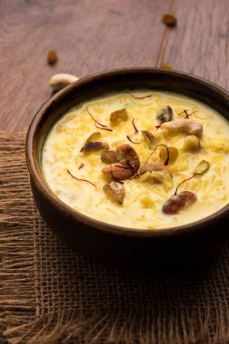 bir Hint tatlı kuru meyve Topingler ile kahverengi pişmiş toprak kapta kheer ya da sütlaç var