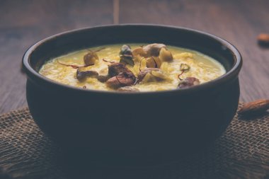 bir Hint tatlı kuru meyve Topingler ile kahverengi pişmiş toprak kapta kheer ya da sütlaç var