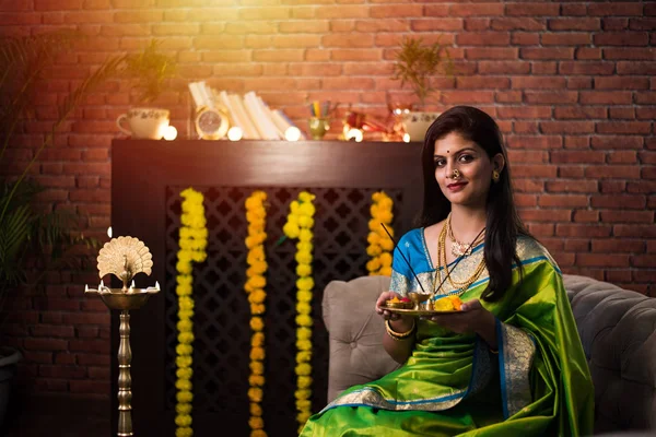 印度女孩 妇女手持Pooja Thali 身穿绿衣 与Rangoli和Samai花一起坐在家里 庆祝Diwali或Hindu节 选择性重点 — 图库照片