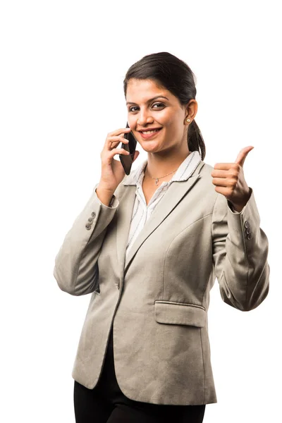 Indian businesswoman in corporate attire calling on smartphone at office while standing isolated over white background