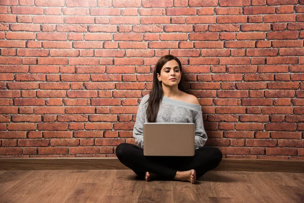 Indian Dziewczyna Laptopem Siedzi Nad Drewnianą Podłogą Czerwonej Cegły Ściany — Zdjęcie stockowe