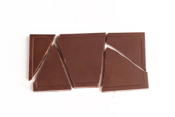Разбитая шоколадная плитка на белом фоне — стоковое фото