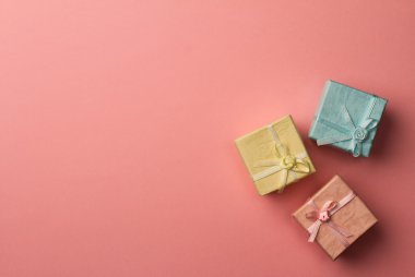 Pembe arka plan şeritler ile üç küçük hediye kutuları