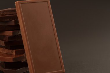 Kare şeklinde koyu arka plan üzerinde çikolata parçaları