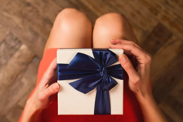 Donna in possesso di una confezione regalo di Natale con nastro blu — Foto Stock