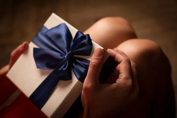 Kadın mavi kurdele ile bir karton hediye kutusu açma