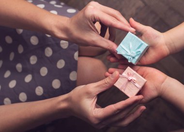 Anne çocuğunu açık el ile iki küçük hediye kutuları verilmesi