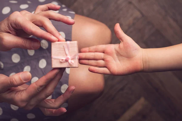 손바닥으로 그녀의 아이 게 작은 선물을 주는 어머니 — 스톡 사진