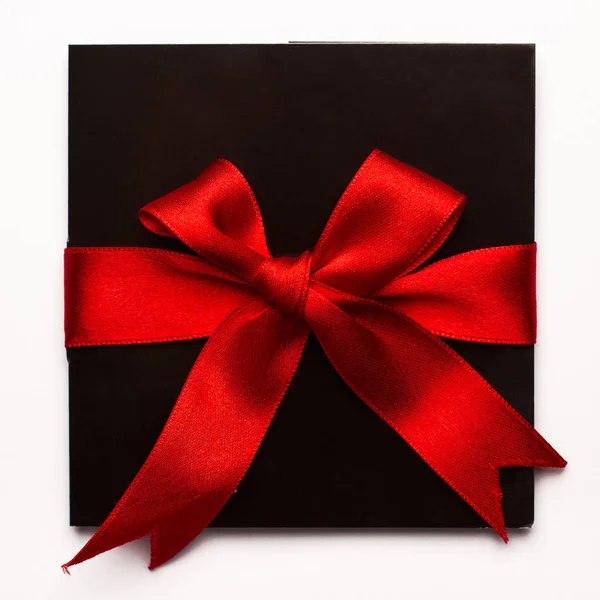 白で隔離赤い繊維リボンと黒い紙カード — ストック写真