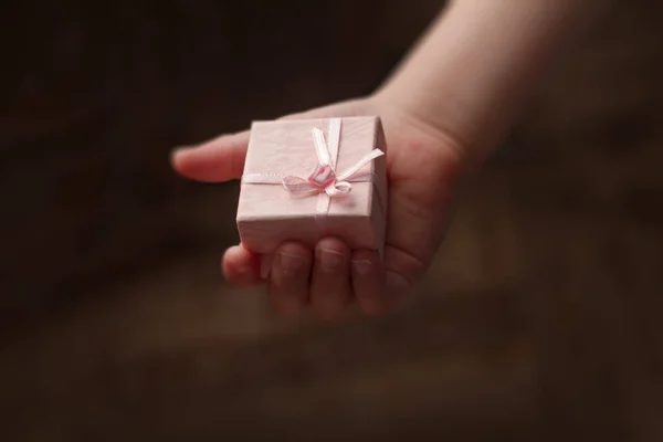 Ruce dítěte drží malé růžové krabičky — Stock fotografie