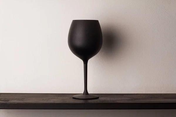 Copo de vinho preto sobre placa de madeira — Fotografia de Stock