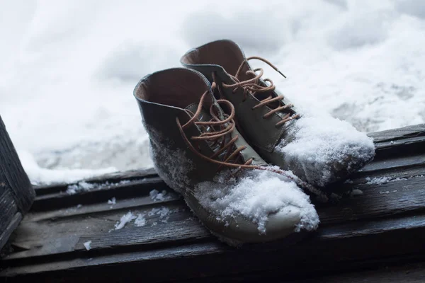 Oryginalne skórzane buty pokryte śniegiem przez drzwi — Zdjęcie stockowe