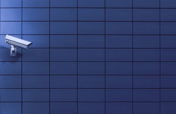 Câmera de vigilância contra uma parede azul — Fotografia de Stock