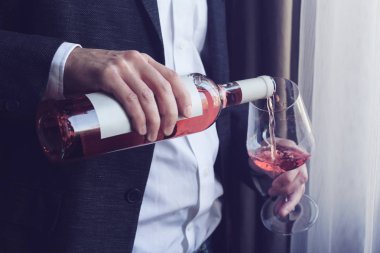 Gül şarap bir bardak dökülen adam
