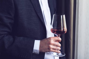Uzun bir gül şarap cam tutan adam