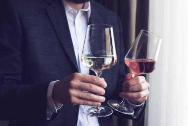 Şarap ile iki uzun boylu gözlük sunan adam 