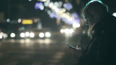 kadın bir trafik ışığı, telefonunu kontrol