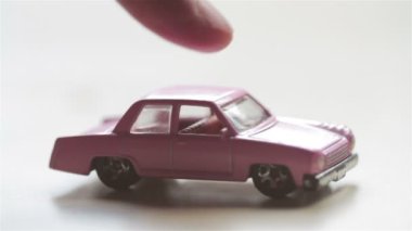 el ile parmak pembe oyuncak araba çerçeve içine iterek.