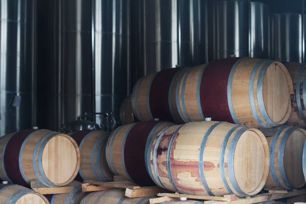 Barris de vinho ao lado de tanques metálicos cromados — Fotografia de Stock