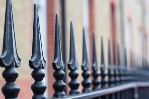 Närbild på svart målat järn staket spikar — Stockfoto