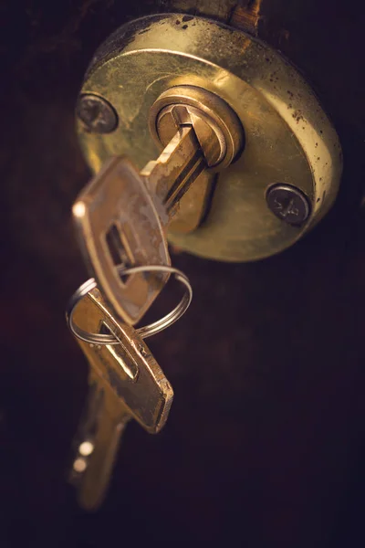 Close-up de par de chaves na fechadura da porta de madeira — Fotografia de Stock