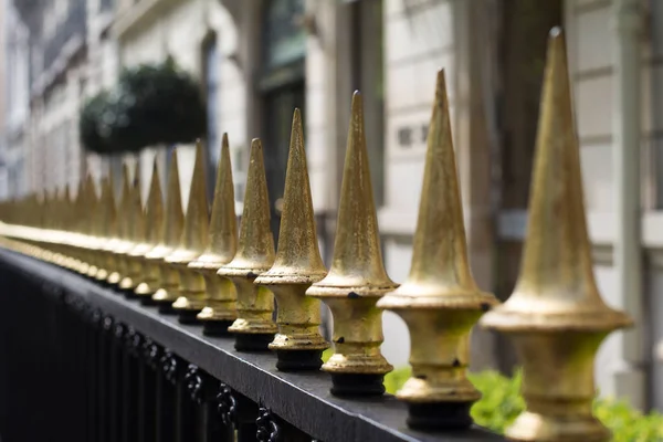 Primo piano di punte di recinzione in ferro verniciato oro — Foto Stock