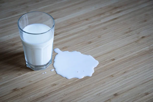 Top View Närbild Glasflaska Pöl Spilld Mjölk Ljusa Trä Bord — Stockfoto