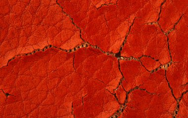 Aşırı kahverengi çatlamış yapay deri arka plan dokusu ve altında sünger olan makro yakın çekim detayı.
