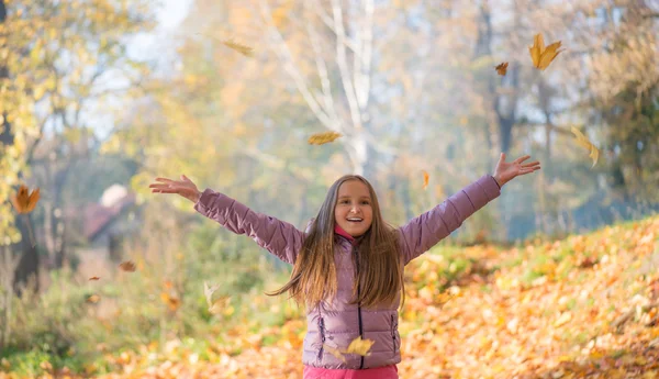 Mutlu bebek kız sonbahar yaprakları atar