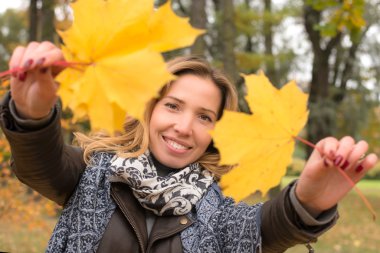gülüyor ve sonbahar yaprakları tutan genç kız